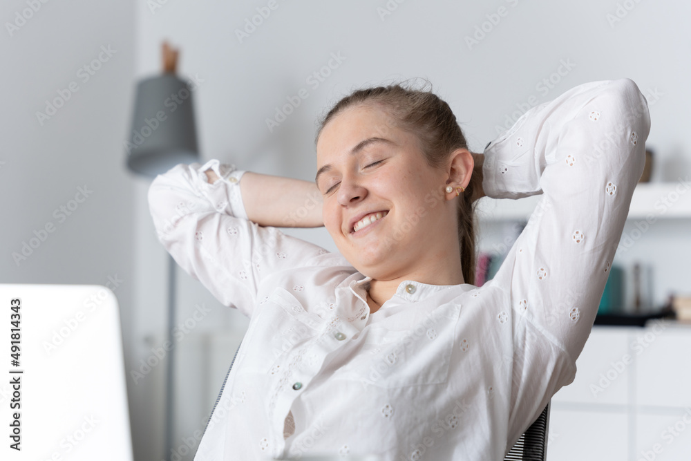 Young smiling businesswoman relaxing and stretching while thinking on financial freedom Young smiling businesswoman relaxing and stretching while thinking on financial freedom