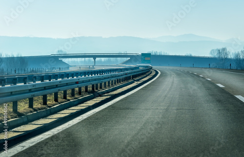 Scenic landscape with exit road sign and Overpass on mountain highway. Side view to tract in highlands. Beautiful scenery with asphalt road with road markings