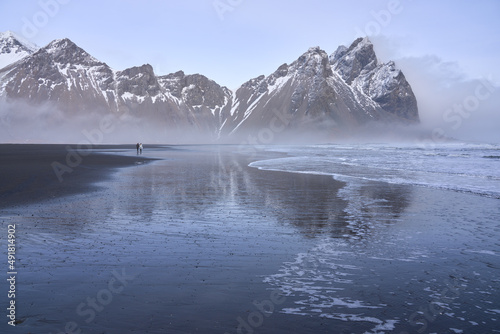 Stokksnes black sand beach and Mt Vestrahorn in winter. People on beach. Southeast Iceland. photo