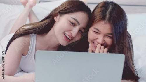 Asian lesbian Lgbt couples watching movies together on the bed in the bedroom at home. Asian young lesbian Lgbt relationship and travel concept for stock footage.