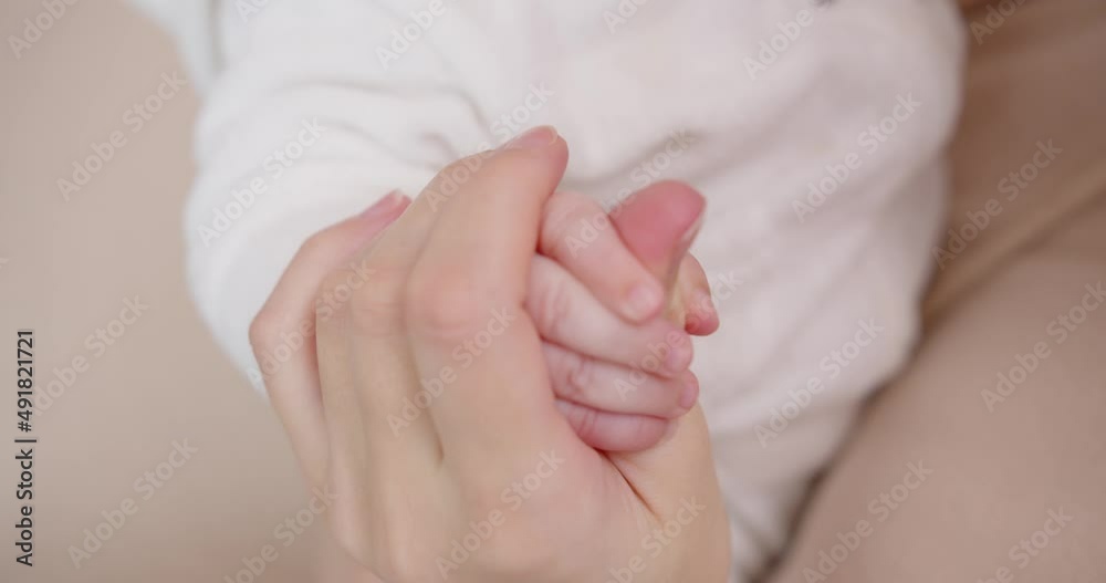 A newborn baby holds a mother's finger with her little pen A newborn baby holds a mother's finger with her little pen