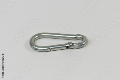 Grey carabiner, mountain climbing snap hook isolated on white background, bag hook