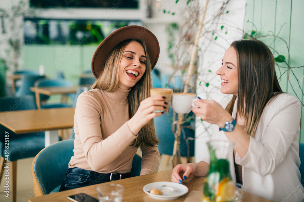women friends drinking coffee in cafe