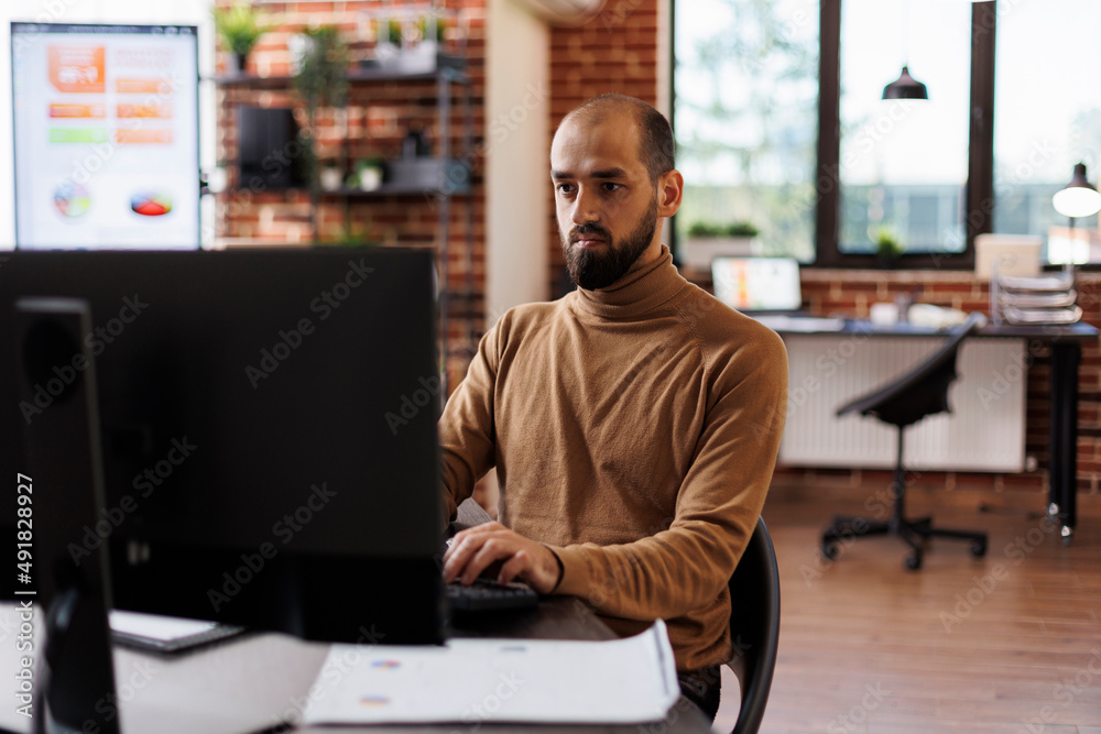 Business company entrepreneur thinking about financial solutions while sitting at desk in office space. Agency accountant sitting in modern workplace while analyzing project presentation.