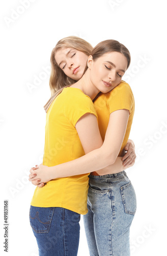 Portrait of hugging young sisters on white background