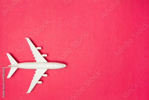 Airplane model. White plane on pink background. Travel vacation concept. Summer background. Flat lay, top view, copy space.
