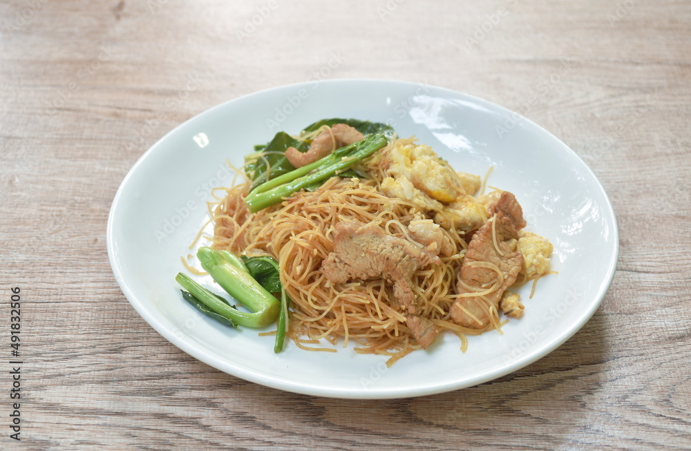stir fried vermicelli thin rice noodles with slice fermenting pork and Chinese kale dressing black sweet soybean sauce on plate stir fried vermicelli thin rice noodles with slice fermenting pork and Chinese kale dressing black sweet soybean sauce on plate