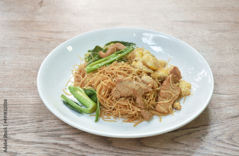 stir fried vermicelli thin rice noodles with slice fermenting pork and Chinese kale dressing black sweet soybean sauce on plate