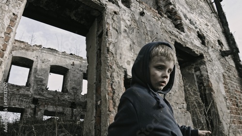 Child playing war in ruins 