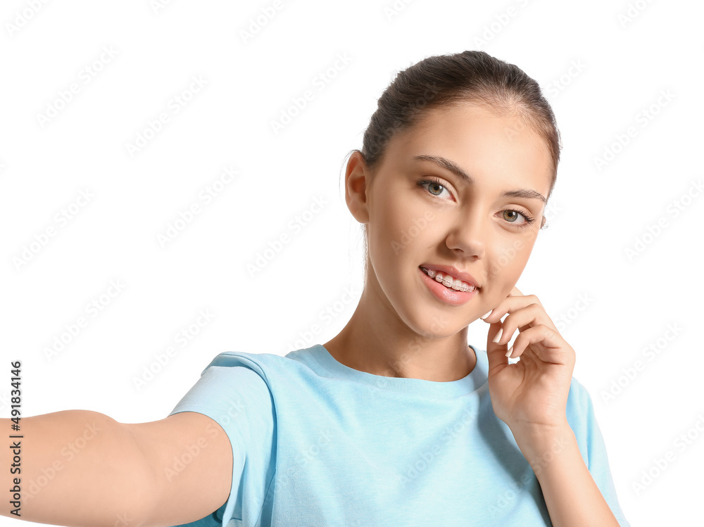 Pretty teenage girl with dental braces taking selfie on white background Pretty teenage girl with dental braces taking selfie on white background