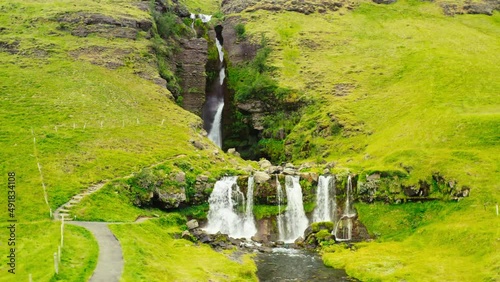 Large Cascade Waterfall Surrounded by Vibrant Green Iceland Backcountry Landscape. HD Aerial Drone. photo