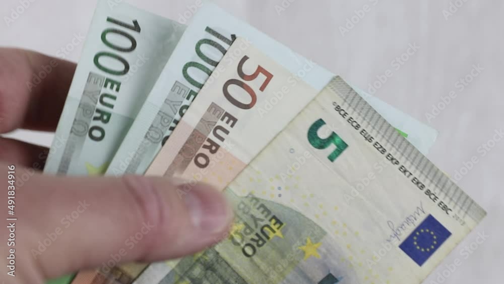 man counting a pack of euro currency cash banknotes close-up. concept of rising price or financial success