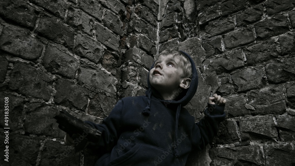 Child playing war in ruins