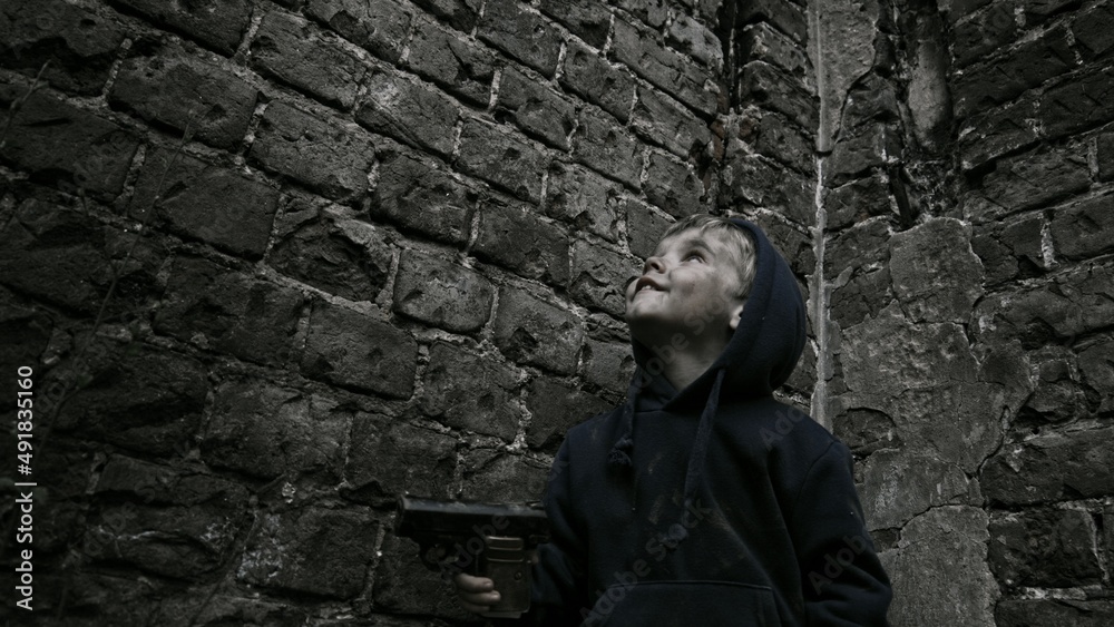Child playing war in ruins