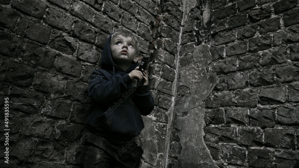 Child playing war in ruins Child playing war in ruins