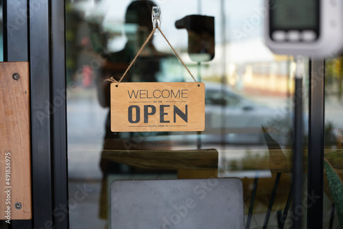 Text on vintage wooden sign "Welcome  we're open please come in " in cafe and restaurant or drink bar beverage