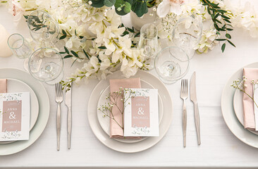 Stylish table setting with wedding invitations and gypsophila flowers, top view