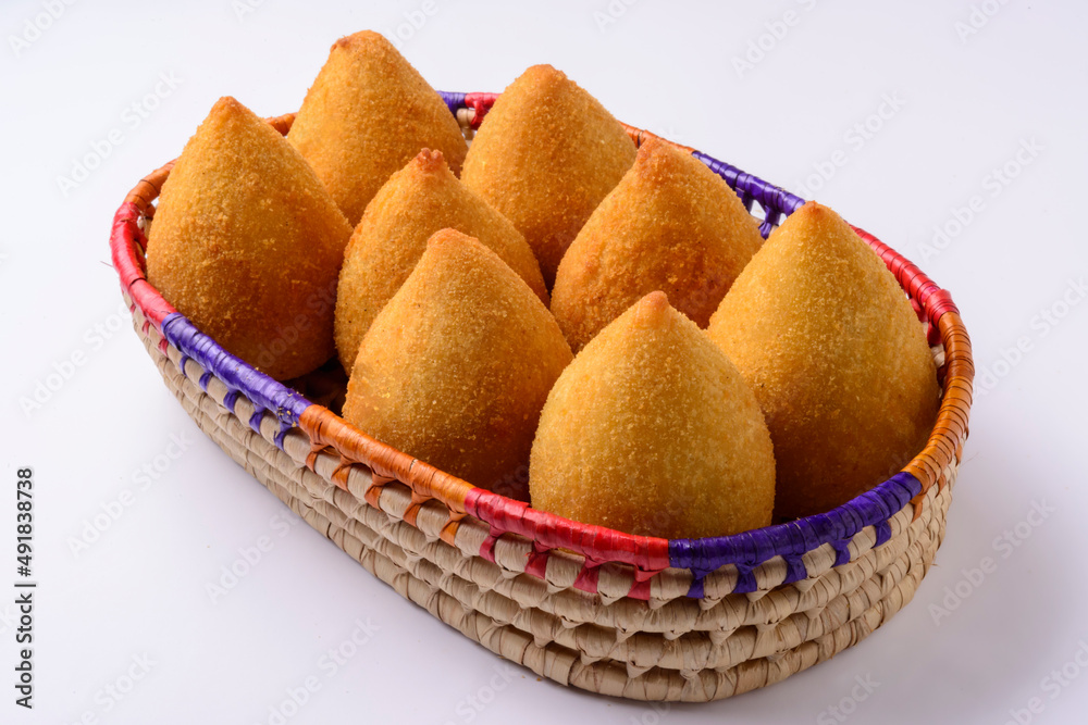 Coxinha of chicken. Brazilian snack inside basket over white background. Coxinha of chicken. Brazilian snack inside basket over white background.