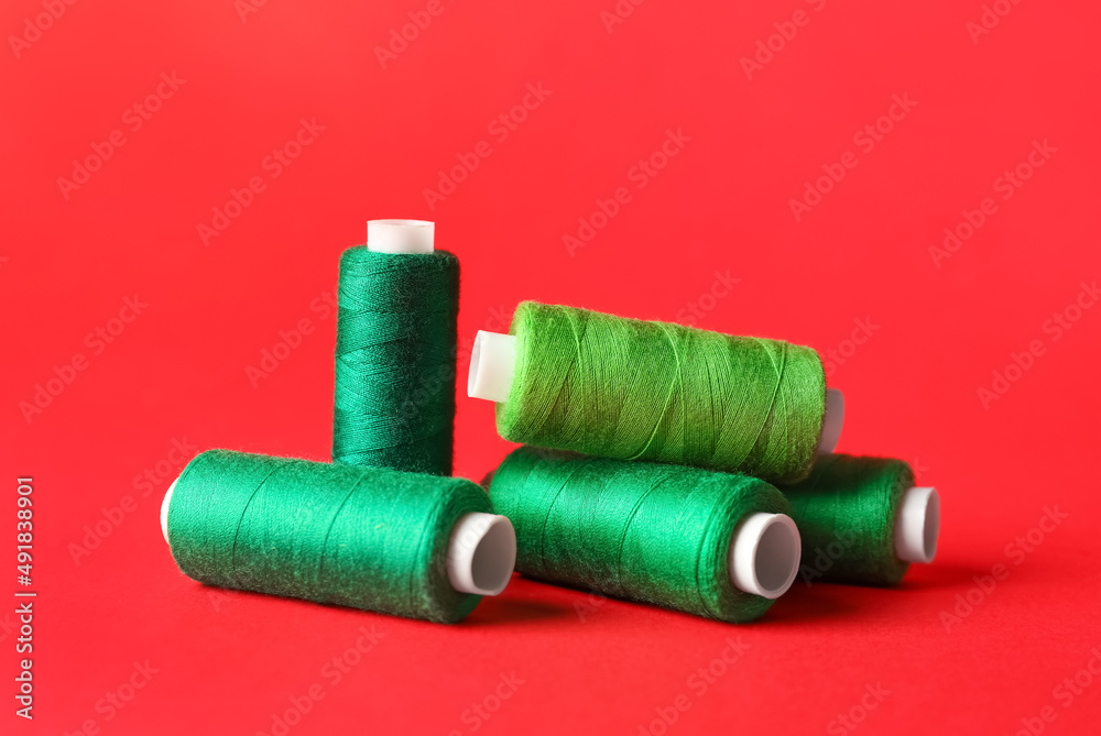 Sewing threads on red background Sewing threads on red background