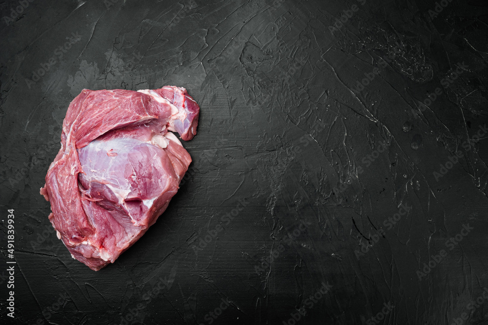Raw Pork meat shoulder, on black dark stone table background, top view flat lay, with copy space for text