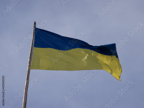 Ukrainian flag pinned on a flagpole against dark blue sky