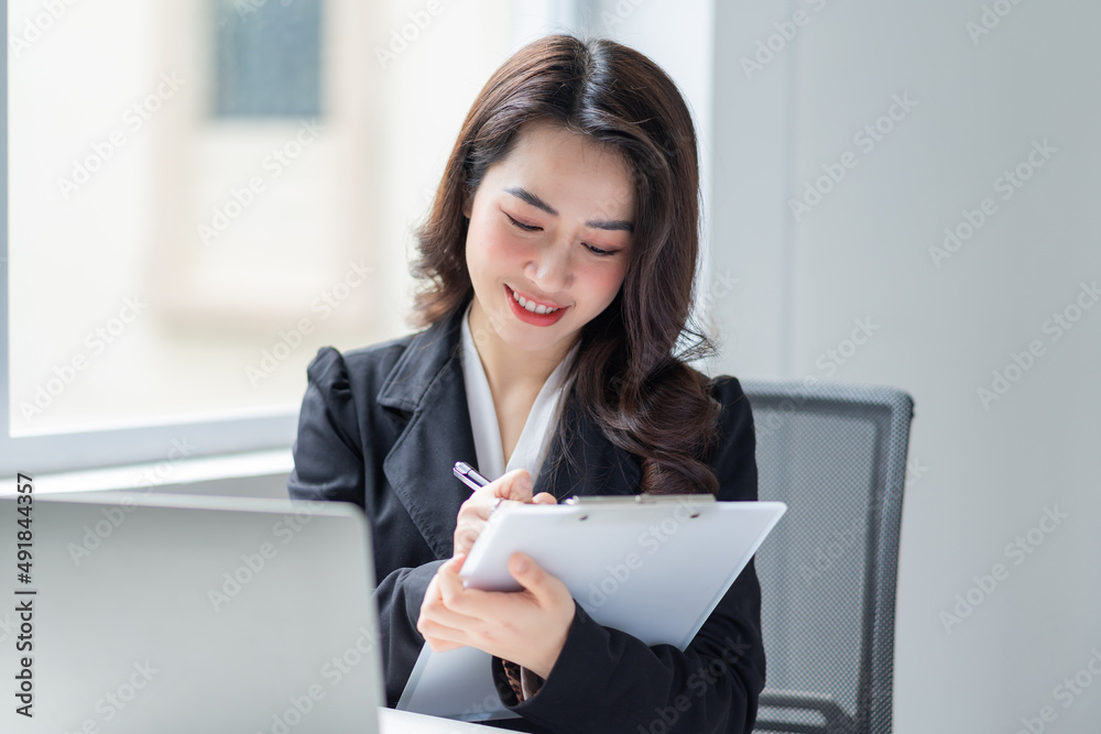 Image of young Asian businesswoman working at office Image of young Asian businesswoman working at office