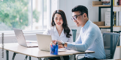 Two Asian businesspeople working at office