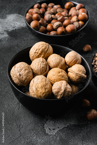 Whole organic walnuts, on black dark stone table background