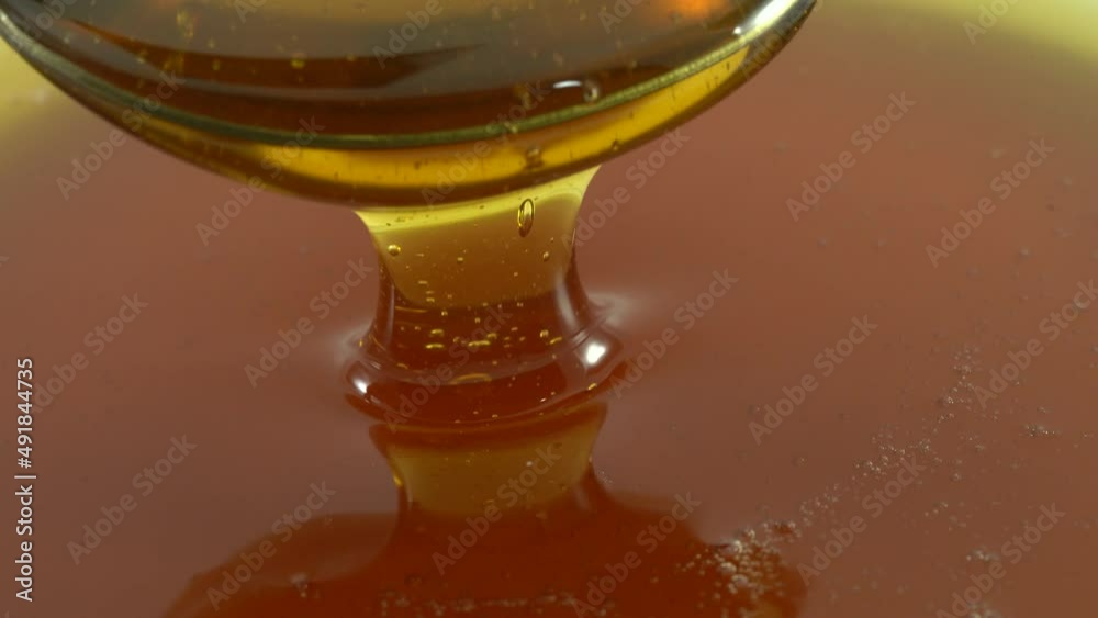 Honey poured from a white bowl is a healthy breakfast ingredient. Honey poured from a white bowl is a healthy breakfast ingredient.