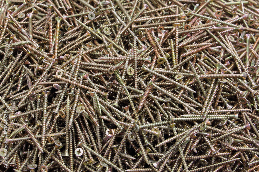 A lot yellow tapping screws for wood, metal screw, iron screw, zinc oxidized screw, screws as a background, wooden screw. A lot yellow tapping screws for wood, metal screw, iron screw, zinc oxidized screw, screws as a background, wooden screw.
