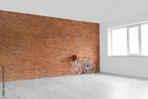 Modern bicycle near brick w...