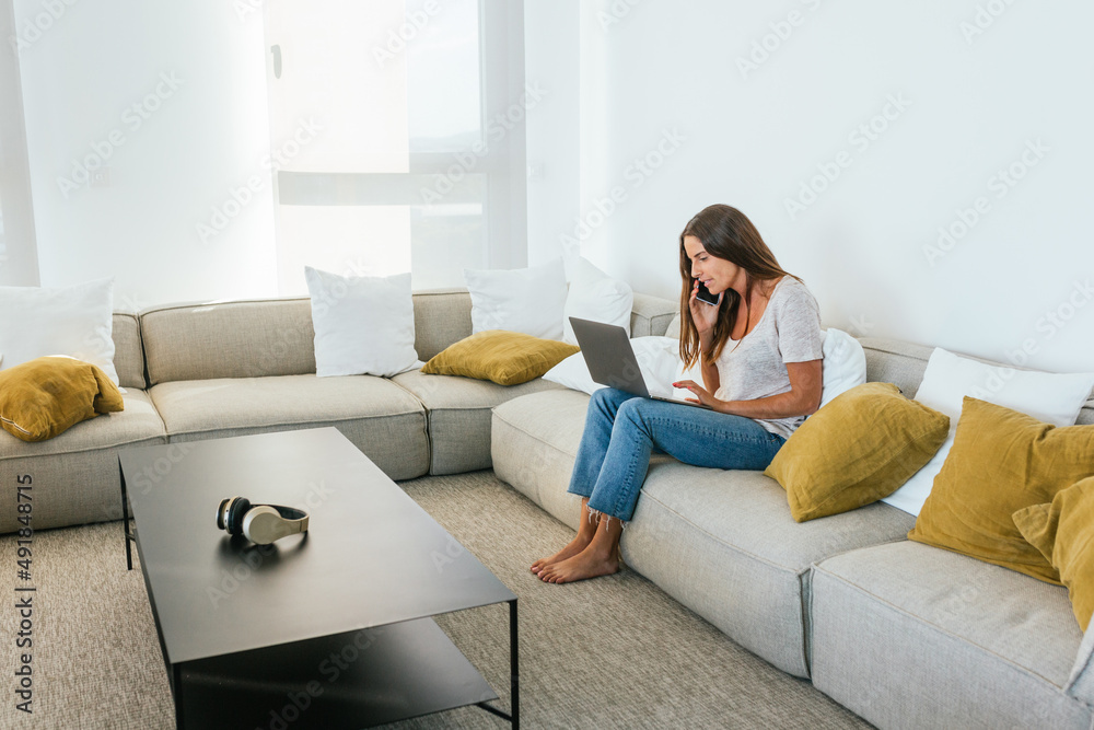 Woman browsing laptop on couch Woman browsing laptop on couch