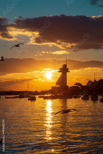 amazing sunset by the seaside. Seagulls flying and boats are ready to sail