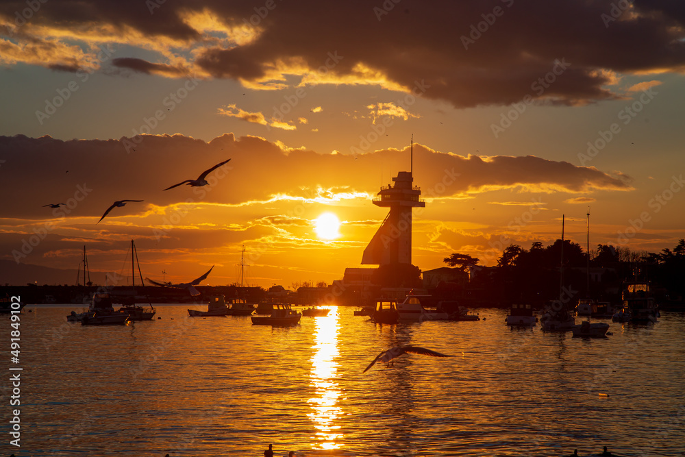 amazing sunset by the seaside. Seagulls flying and boats are ready to sail amazing sunset by the seaside. Seagulls flying and boats are ready to sail