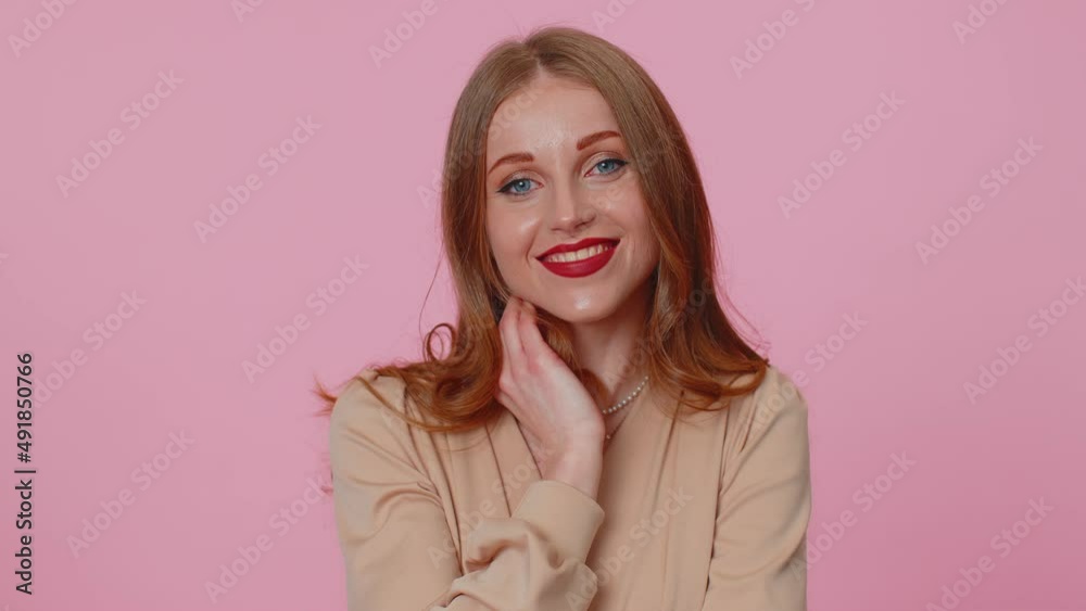 Smiling playful happy businesswoman girl in beige blouse blinking eye, looking at camera with toothy smile, winking, flirting, expressing optimism. Young pretty adult woman on pink studio background Smiling playful happy businesswoman girl in beige blouse blinking eye, looking at camera with toothy smile, winking, flirting, expressing optimism. Young pretty adult woman on pink studio background