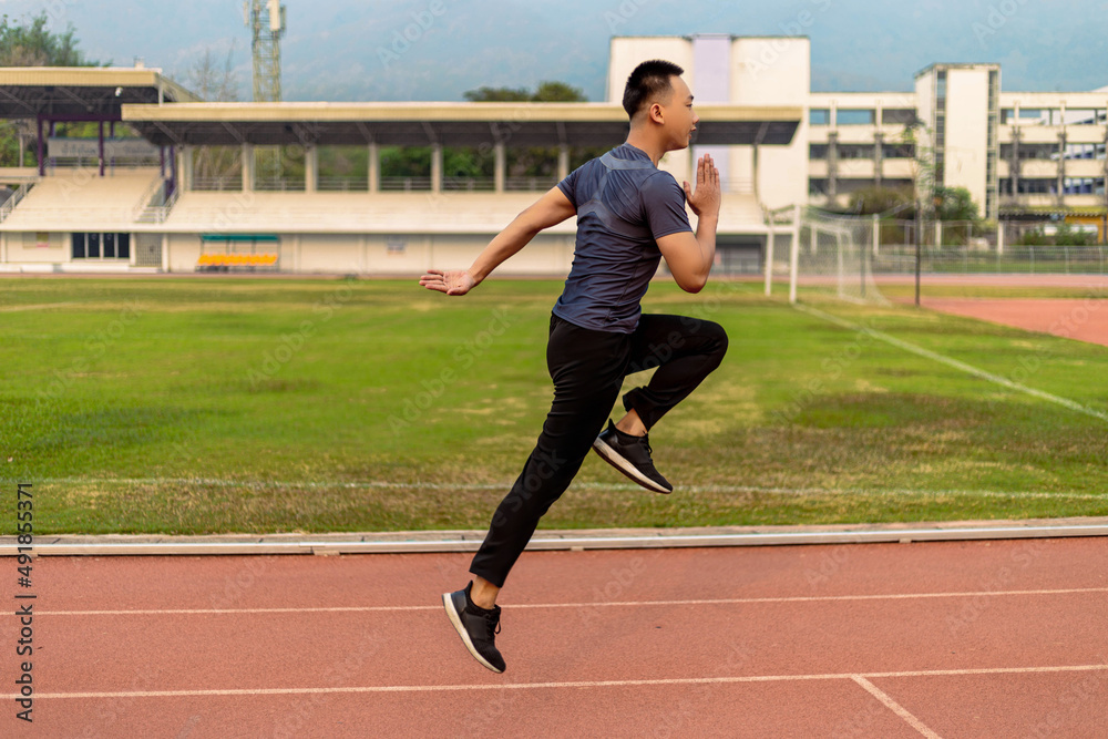 Obraz premium Sports and recreation concept a young male adult running in low speed in the sports stadium as his healthy routine in the evening