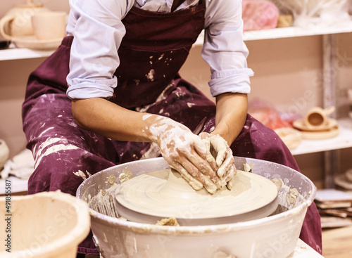 Woman Pottery Artist. Workshop Molding Clay On Pottery Wheel. Ceramic Studio. Mid Section View . Female Hands Shapes Clay.