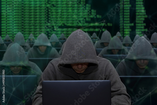 Hackers are sitting at laptops and computers on an abstract background, attacking and hacking servers with a virus. Creation and dissemination of disinformation, DDOS attack.