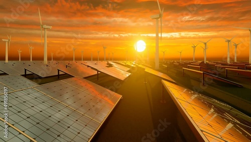 Sunset with orange sky over wind turbines and solar panel field