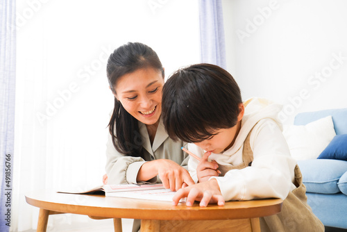 家でお母さんと一緒に勉強をする男の子 © maroke