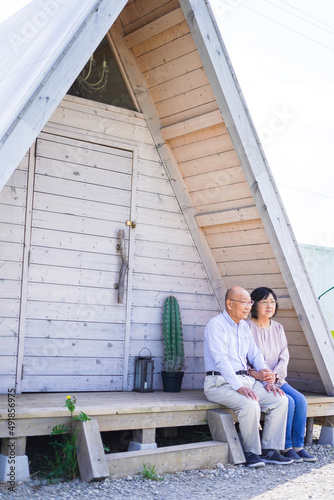 別荘の前に座るシニアの夫婦