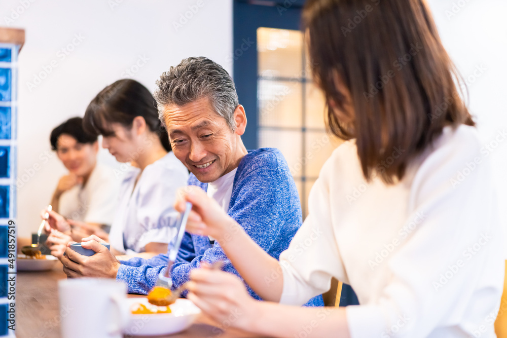 レストランのカウンター席でご飯を食べる人々