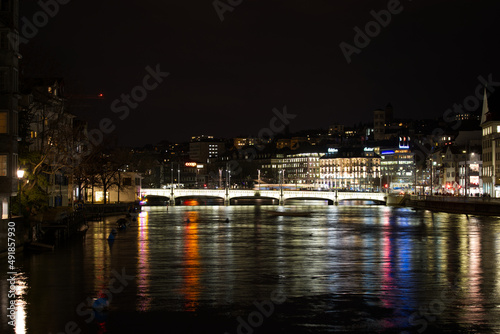 Cityscape of the old medieval old town of Z  rich on a dark winter night with river Limmat in the foreground and beautiful reflections in water. Photo taken February 24th  2022  Zurich  Switzerland.