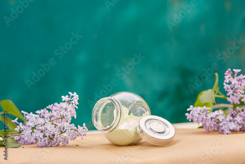 Face care alginate mask. Wellbeing cosmetic: multitasking beauty product. Scinimalism concept, polytasking functions. Natural lilac flower. Dermatology cosmetics. Copy space. photo