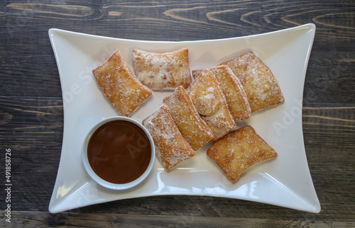 Zeppoli, Italian doughnuts with powdered sugar and chocolate dipping sauce. photo