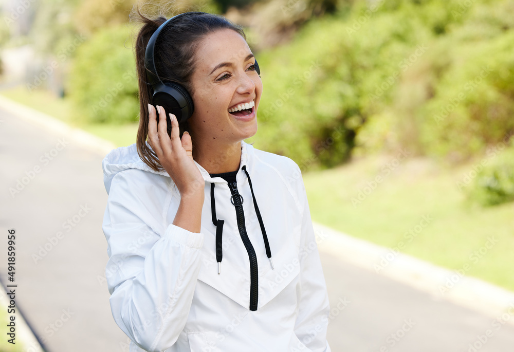The music gets her motivated. Cropped shot of an attractive and athletic young woman listening to music while standing outdoors. The music gets her motivated. Cropped shot of an attractive and athletic young woman listening to music while standing outdoors.