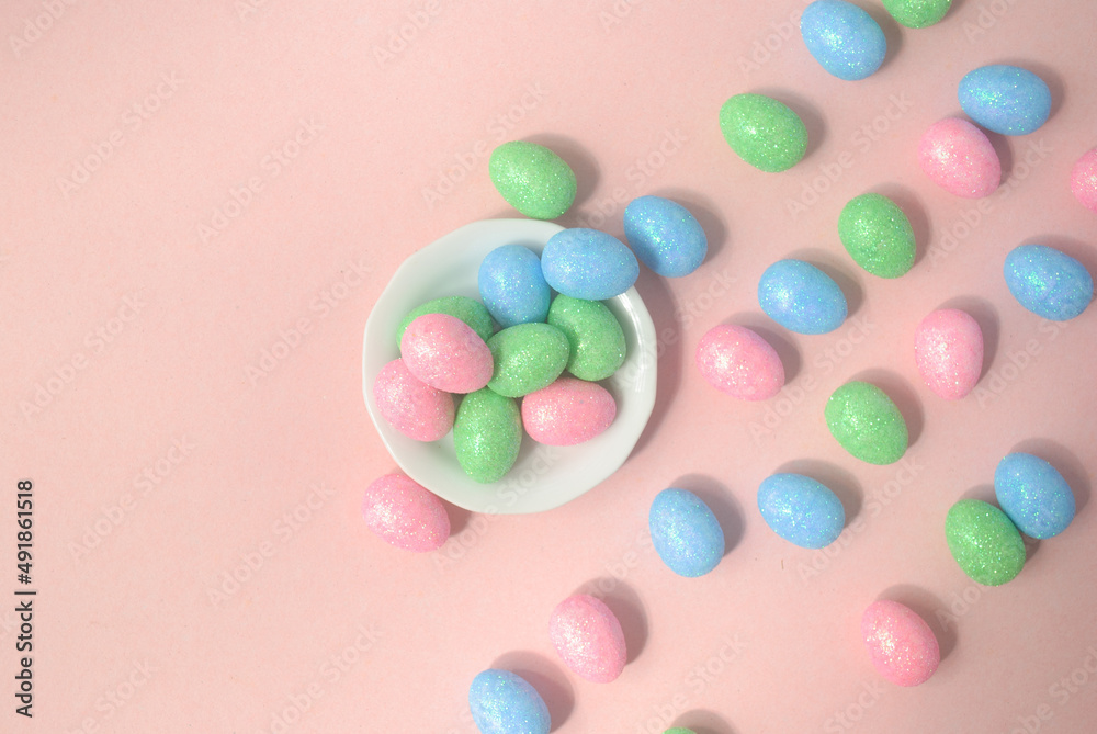chocolate Easter eggs in a white plate on a pink background chocolate Easter eggs in a white plate on a pink background