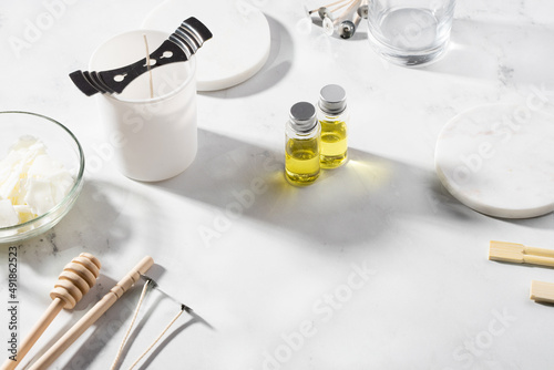 Set tools for homemade natural eco-friendly soy wax candles, wick, perfume, essential oil on a marble table. Making process. Trendy DIY. Craft hobby, small business, artisan products concept