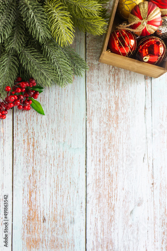 Christmas background, red ornaments and pine leaves on wooden table top for festive decoration.
