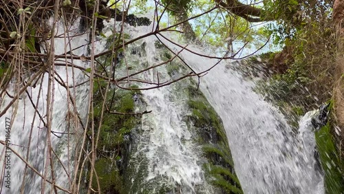 Waterfall in the forest with rocks covered in moss photo